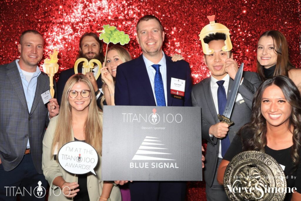 Group smiling with photobooth props at Phoenix Titan 100 ceremony