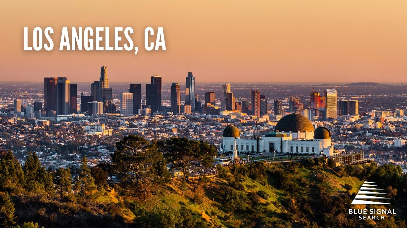 Aerial view of downtown Los Angeles, CA, at dusk with the Griffith Observatory in the foreground.