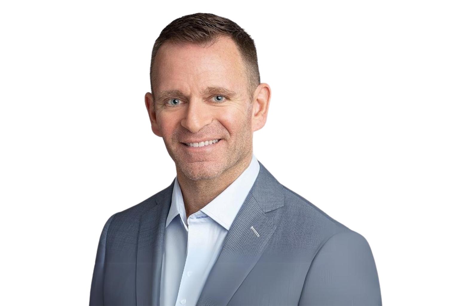 Professional headshot of Adam Fiore, Director of Executive Search at Blue Signal, wearing a light blue dress shirt and a gray blazer, smiling confidently at the camera