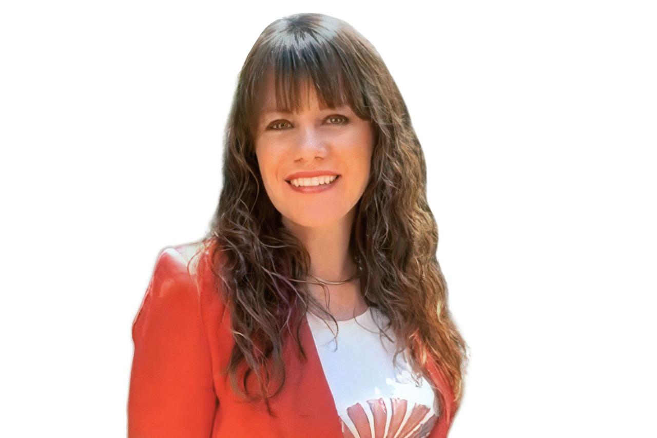 Professional headshot of Jessie Robinson, a recruiter with expertise in Consumer Packaged Goods and SaaS industries. Jessie is smiling warmly, wearing a red blazer over a white top with a decorative design, with long, wavy brown hair.