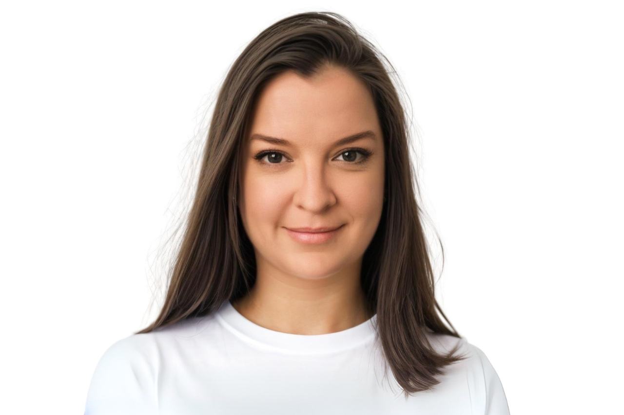 Caucasian woman with brown hair with a soft smile wearing a white shirt with a white background.