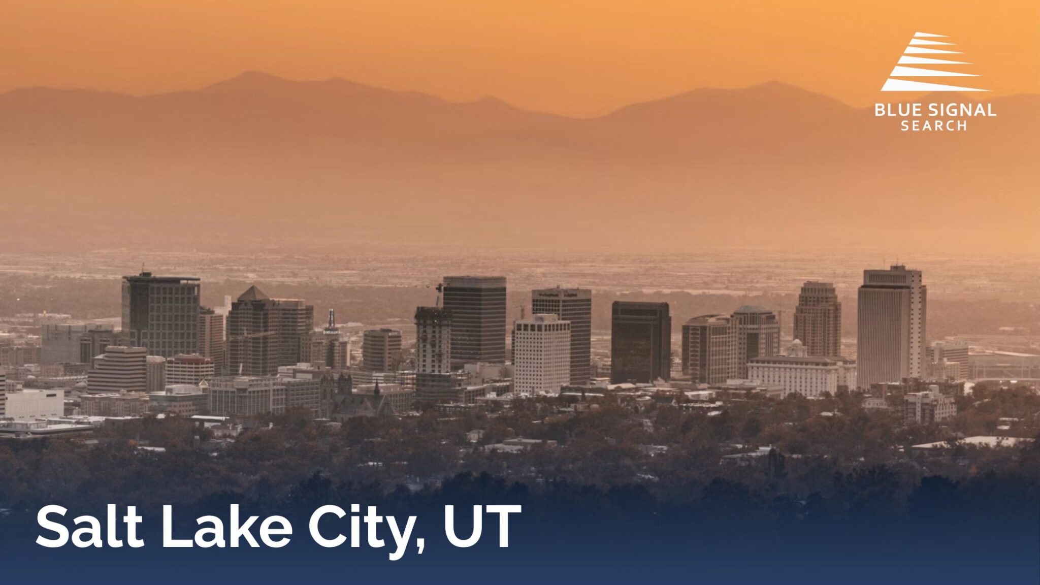 Salt Lake City skyline with Wasatch Mountains in the background during sunset.