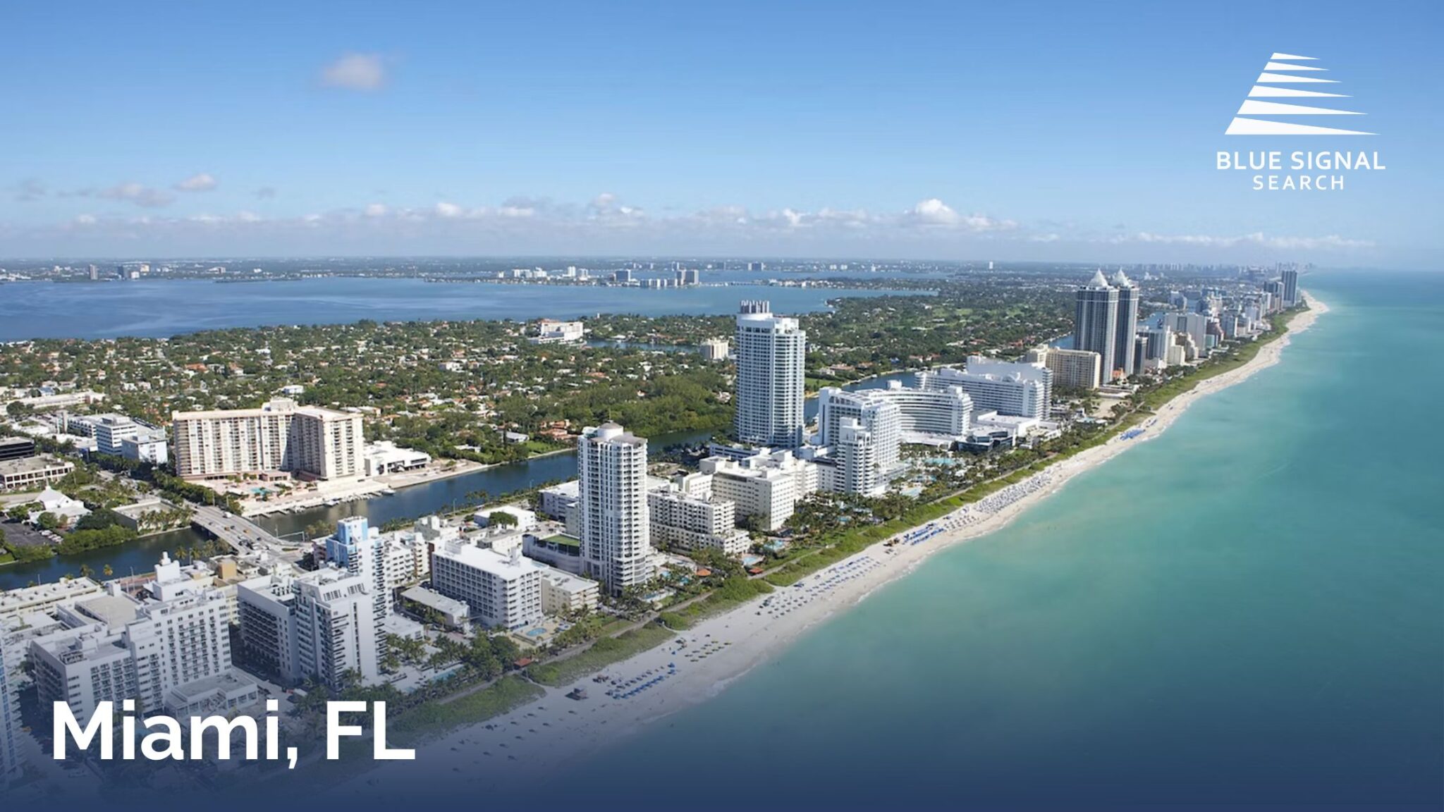 Aerial view of Miami Beach with oceanfront high-rise buildings, white sand beaches, and Biscayne Bay.