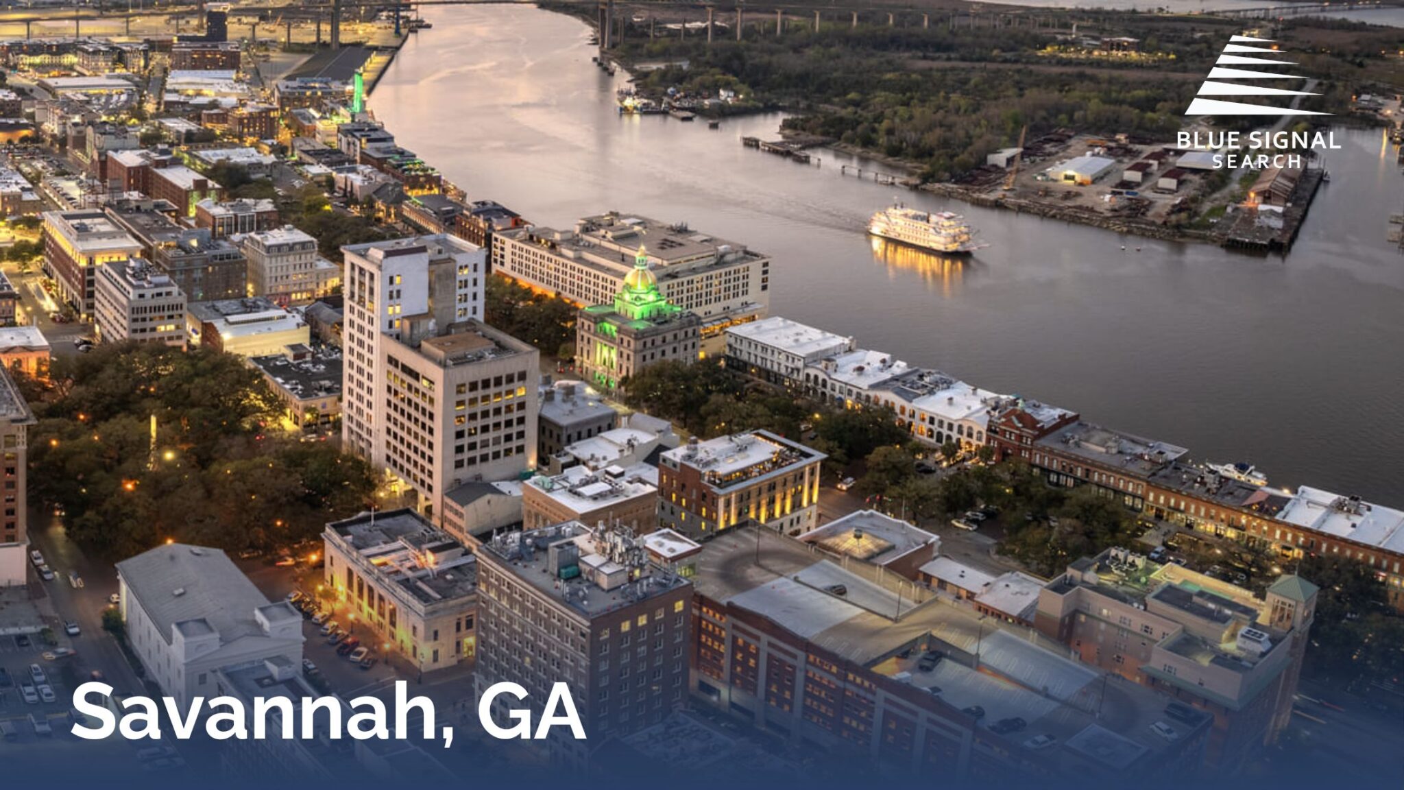 Aerial view of historic downtown Savannah and the Savannah River at dusk.